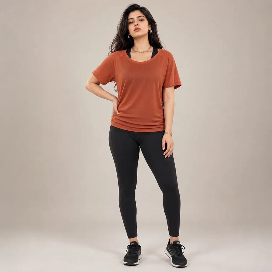 Woman modeling a rust moisture-wicking performance gym tee