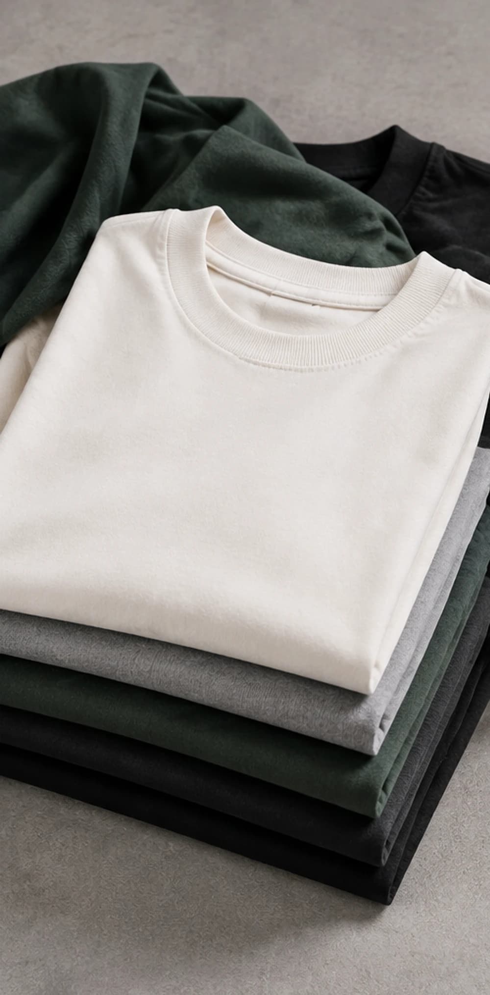 Folded, undecorated oversized tee blanks stacked by colour