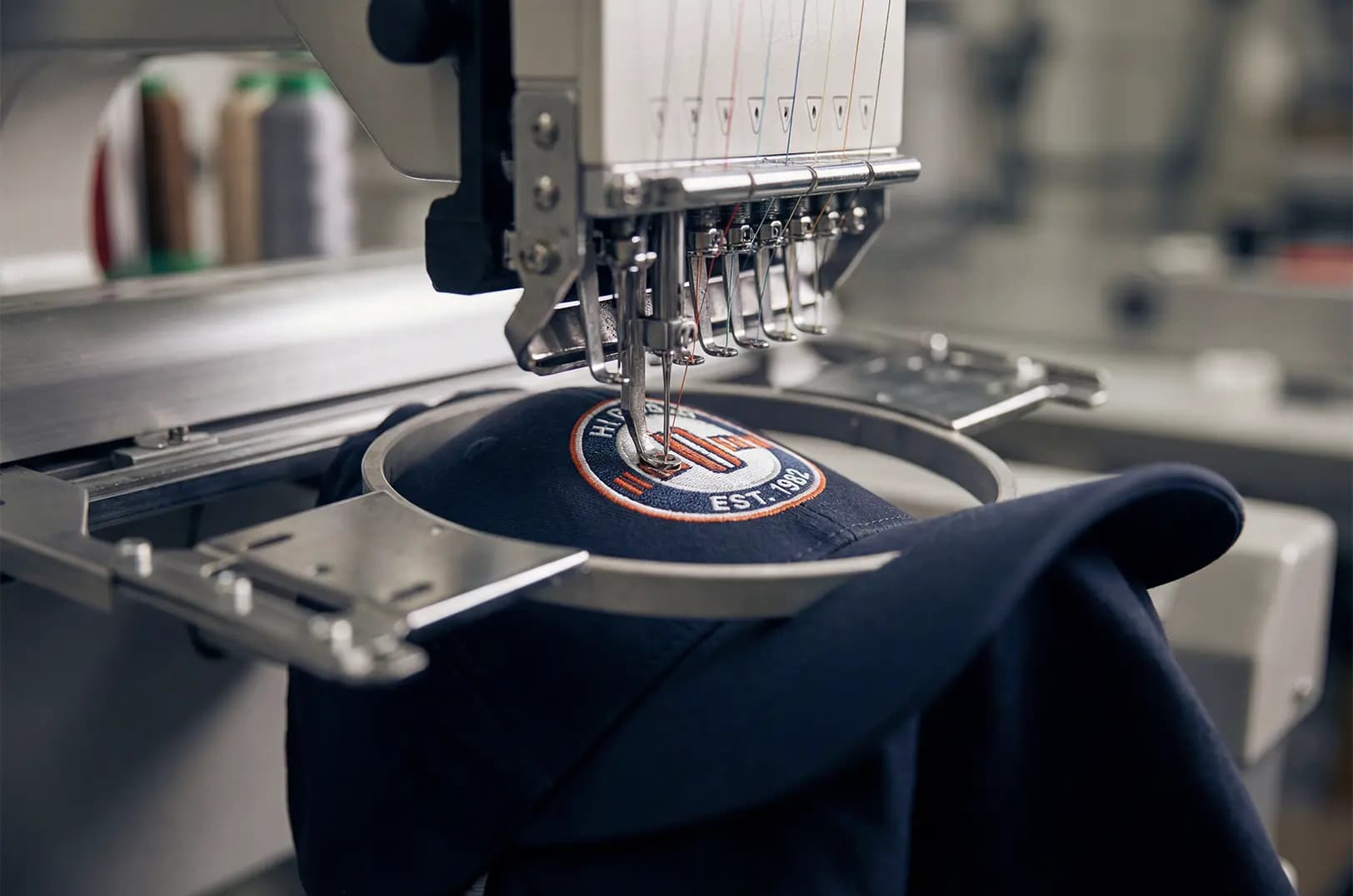 Embroidery machine stitching a crest badge in the hoop